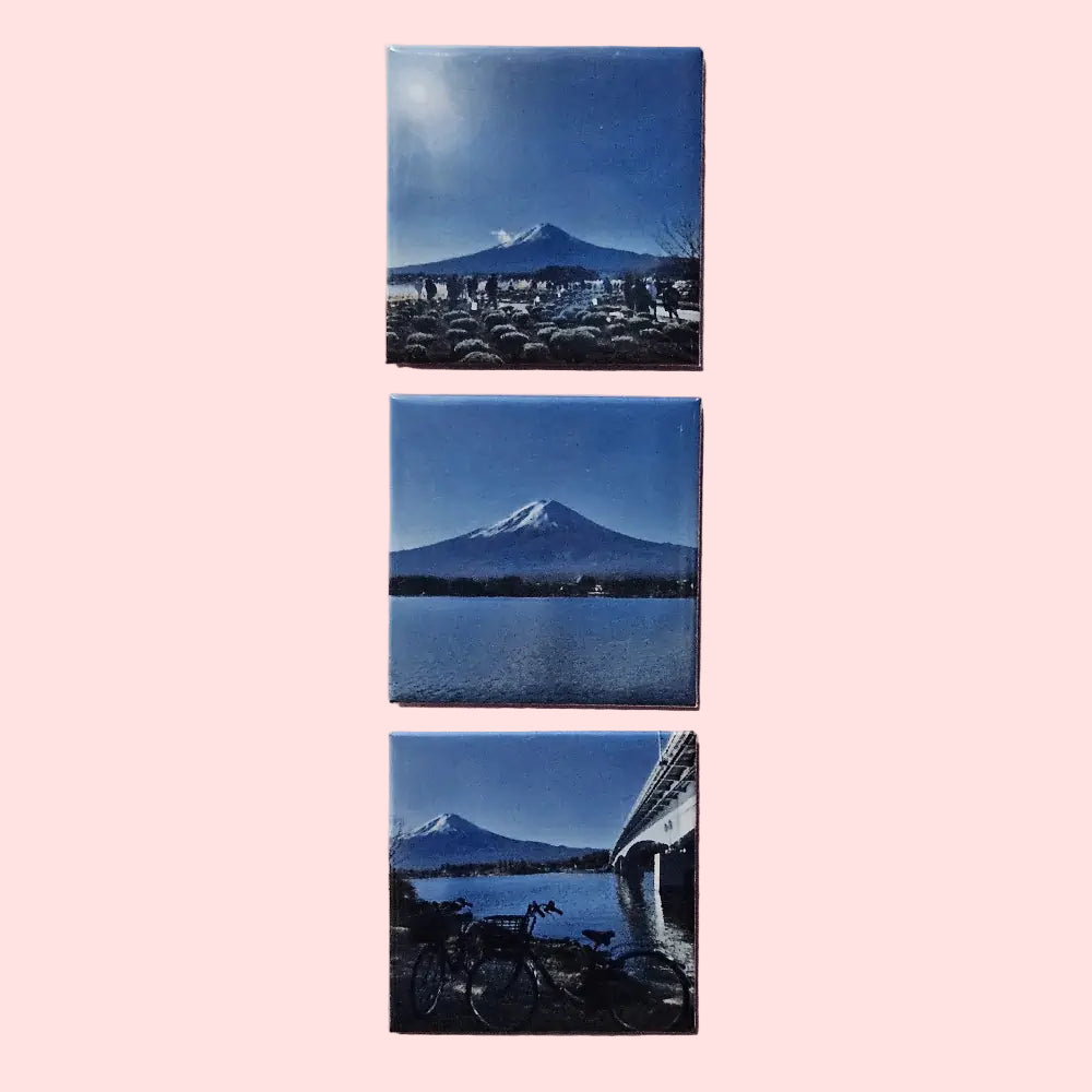 Set of three square tiles with mountain landscapes on a light pink background